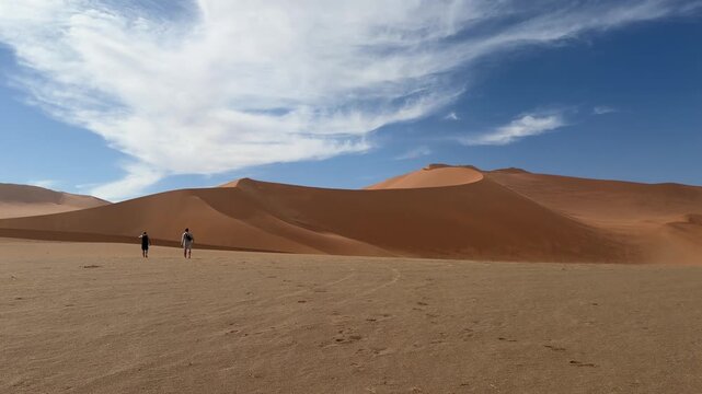 Two male adult adventurers exploring dunes in Sossusvlei Desert, Namibia Africa