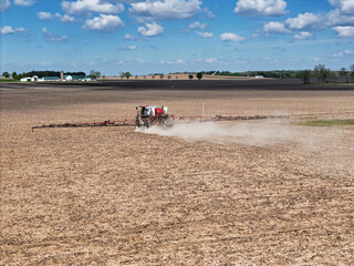 Self-propelled field sprayer applying herbicide to a farm field. © dvande