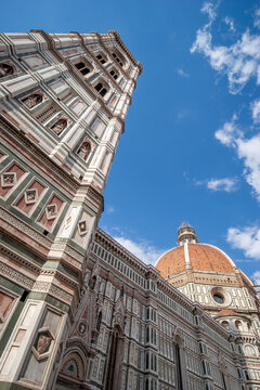Florence Duomo and tower. Low angle view looking up at Giotto campanile and Brunelleschi dome in Italy.