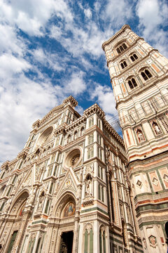 Florence Duomo facade. Intricate marble exterior of Giotto bell tower and cathedral under blue sky.