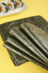 Nori Seaweed Sheets for Sushi Making with Japanese Rolls on Yellow Background © ThiLe