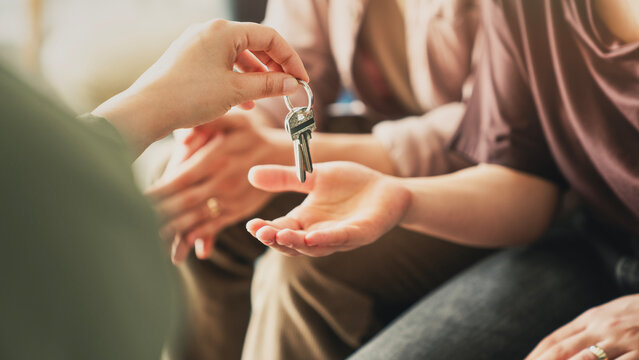 Real estate agent giving house keys to couple