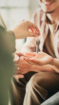 Real estate agent giving house keys to couple