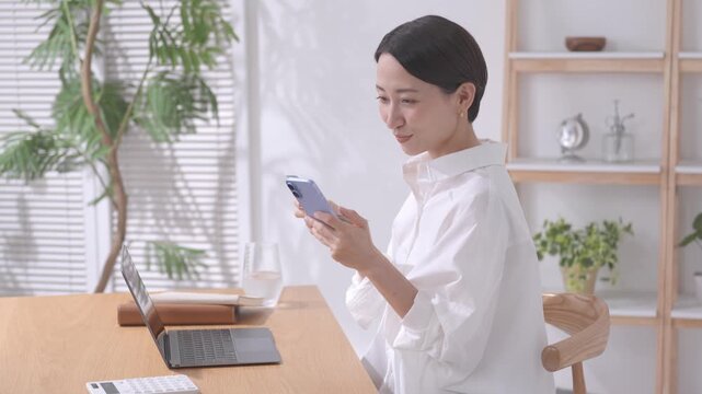 スマホと通帳を見る女性