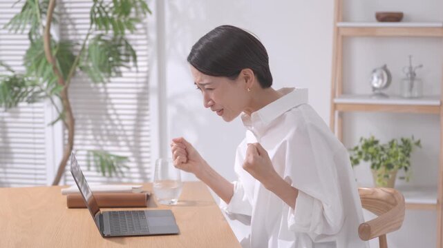ノートパソコンを見て応援する女性