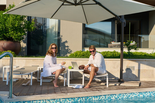 Couple Enjoying Breakfast and Relaxation by a Private Pool on a Sunny Terrace