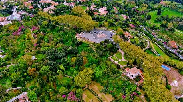 Aerial view of Janiculum Hill in Rome, Italy, with the Garibaldi monument square, the botanical garden, the Acqua Paola fountain, villas, umbrella pines and blossoming trees in spring.