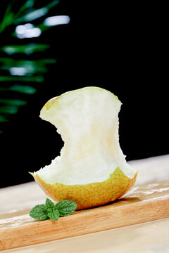 Fresh Jade Pear with Bite Mark and Mint Garnish from Shanxi China on Wooden Board