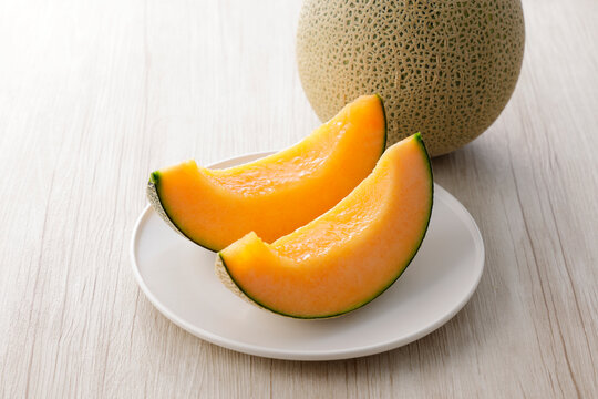 テーブルに置かれた北海道産の赤肉カットメロン　Cut orange flesh Japanese melon on a table, Hokkaido cantaloupe