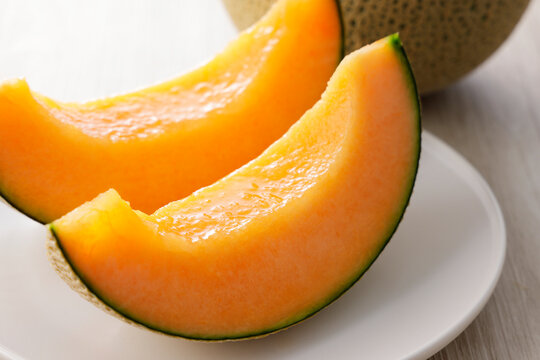テーブルに置かれた北海道産の赤肉カットメロン　Cut orange flesh Japanese melon on a table, Hokkaido cantaloupe