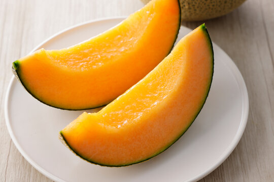 テーブルに置かれた北海道産の赤肉カットメロン　Cut orange flesh Japanese melon on a table, Hokkaido cantaloupe