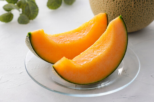 テーブルに置かれた北海道産の赤肉カットメロン　Cut orange flesh Japanese melon on a table, Hokkaido cantaloupe