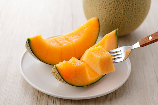 テーブルに置かれた北海道産の赤肉カットメロン　Cut orange flesh Japanese melon on a table, Hokkaido cantaloupe