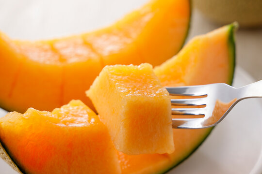 テーブルに置かれた北海道産の赤肉カットメロン　Cut orange flesh Japanese melon on a table, Hokkaido cantaloupe