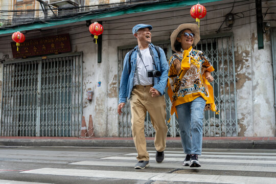 Happy Senior Asian Couple Sightseeing and Exploring Old Town Street
