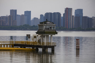 Traditional pavilion on urban waterfront with modern skyline © PhungBao