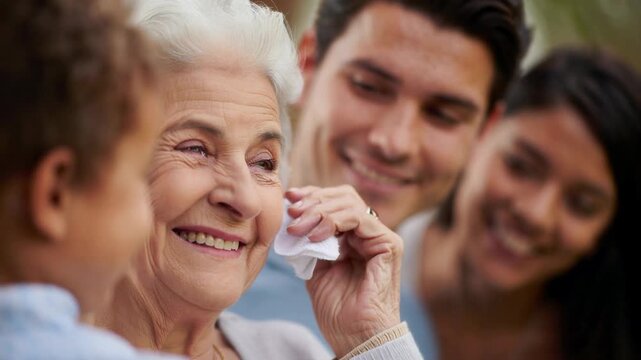 Family reunion with tearful grandmother holding tissue, multigenerational relatives sharing comfort, senior woman near smiling loved ones, heartfelt bonding, care, support, tenderness, scene
