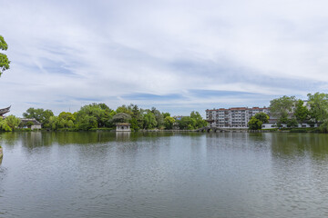 Fototapeta premium Tranquil urban lake with Chinese pavilion and bridge in spring
