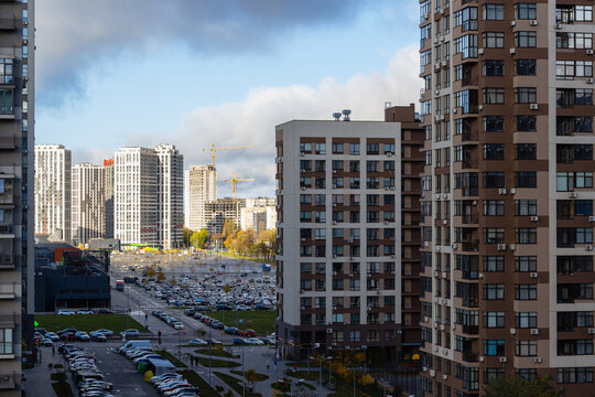 Modern residential skyscrapers and busy city streets in Kyiv, Ukraine, under dramatic storm clouds. Contemporary urban architecture, construction, traffic and resilient city development in 2023