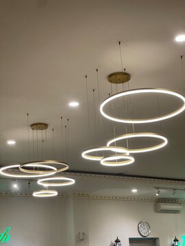 Modern circular LED pendant lights hanging from a white ceiling in a contemporary interior.