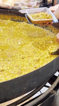 Traditional Argentine locro being served into a takeaway container