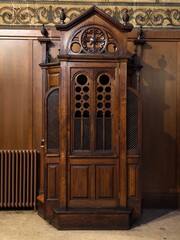 Antiguo confesionario de madera en el interior de una iglesia católica © Fabian