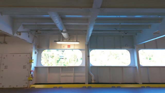 Wide angle view inside the empty vehicle parking deck of a large passenger ferry