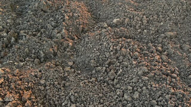 Close-up top-down view of dark volcanic soil and rocks from Kula Geopark in Turkey, fa01