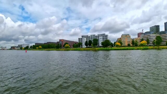 Modern Residential Waterfront Along the IJ River in Amsterdam Under a Dramatic Cloudy Sky