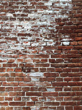 Old red brick wall texture with white peeling paint background.