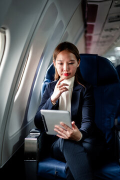 business woman works on digital tablet during business flight tr
