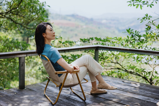 Woman Relaxing on Scenic Wooden Deck Overlooking Nature