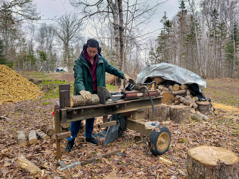 Focused woman using a log splitting machine