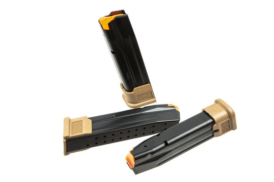Three 9mm pistol magazines with tan extensions isolated on white back