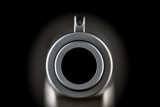 Extreme close-up of a firearm barrel opening, dark, with metal textures