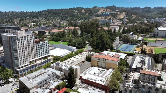 Berkeley, California, USA - Aerial Drone Pullback View of Downtown With Tree-Lined Neighborhoods and Rolling East Bay Hills and High Buildings Next to University Campus