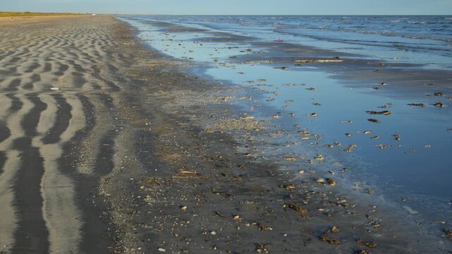 Louisiana, USA &ndash; coastal shoreline with distinct ribbed sandy formations on the left and shallow water on the right.