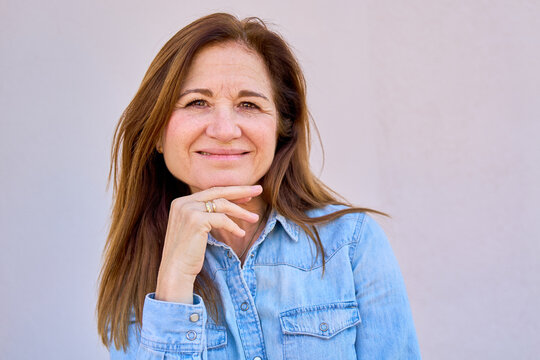 Mature woman smiling, expressing confidence and contentment