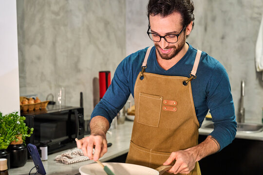 Man cooking healthy meal in modern kitchen