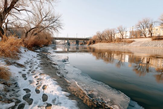 Frozen river with footprints in snow and thick ice under pale winter sky