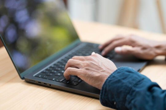 Hands of business man typing during working with laptop computer on the table