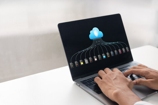 Hands typing on laptop with cloud storage icon. Secure cloud backup interface displaying multiple digital file formats for business data management.