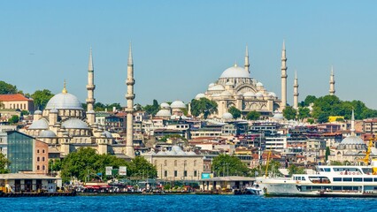 Fototapeta premium Istanbul, Turkey - July 11, 2026: View of the New Mosque, Süleymaniye Mosque, and Istanbul city from the Bosphorus, showing historic domes, minarets, waterfront buildings, and city skyline