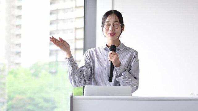 プレゼンテーションをする30代日本人女性