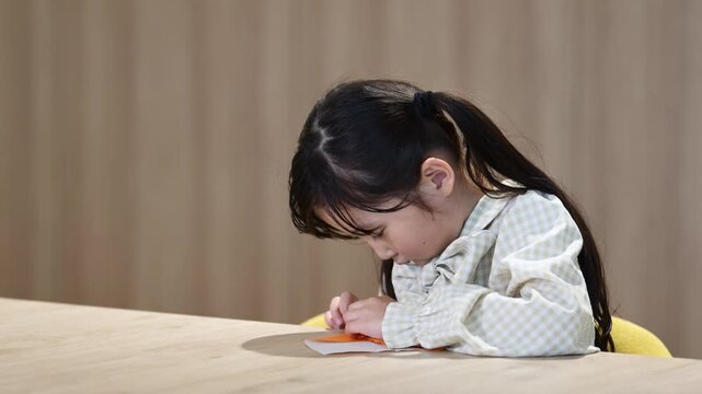 折り紙に真剣に取り組む6歳日本人の女の子