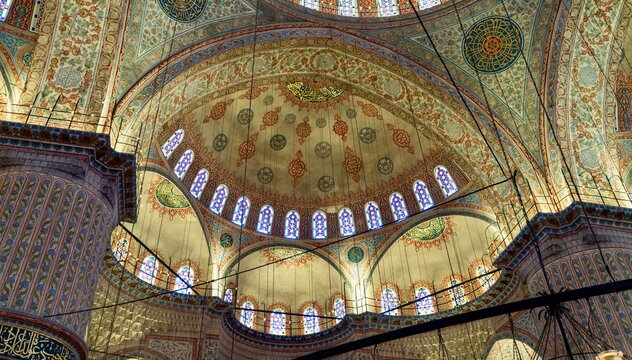 Istanbul, Turkey - July 11, 2026: View of the painted domes inside Sultanahmet Mosque in Istanbul, Turkey, showing ornate Ottoman interior decoration, blue tile patterns, and Islamic calligraphy