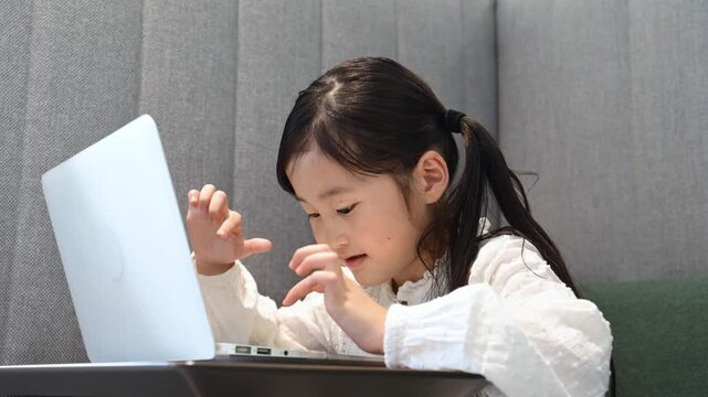 コワーキングスペースでノートパソコンを使う6歳日本人女の子