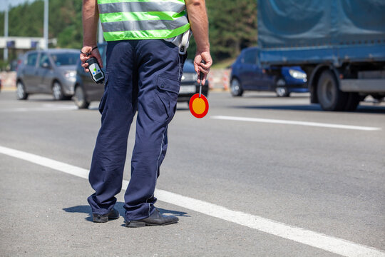 Traffic Police Officer Holding Stop Paddle and Breathalyzer During Highway Roadside Alcohol Check