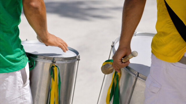 Men playing drums on Brazil Independence Day. Percussionists performing at street parade in green and yellow flag colors. Musical celebration of national holiday in Latin America.