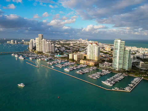 Aerial view of luxury yachts in Miami marina. Scenic panorama of boats and skyscrapers in Miami marina. Cruise yacht sailing along the Miami coastline. Miami Beach harbor. Sailboats and yachts at pier